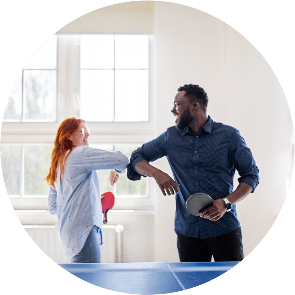 Curate Partners | Home Two young people playing ping pong bumping elbows